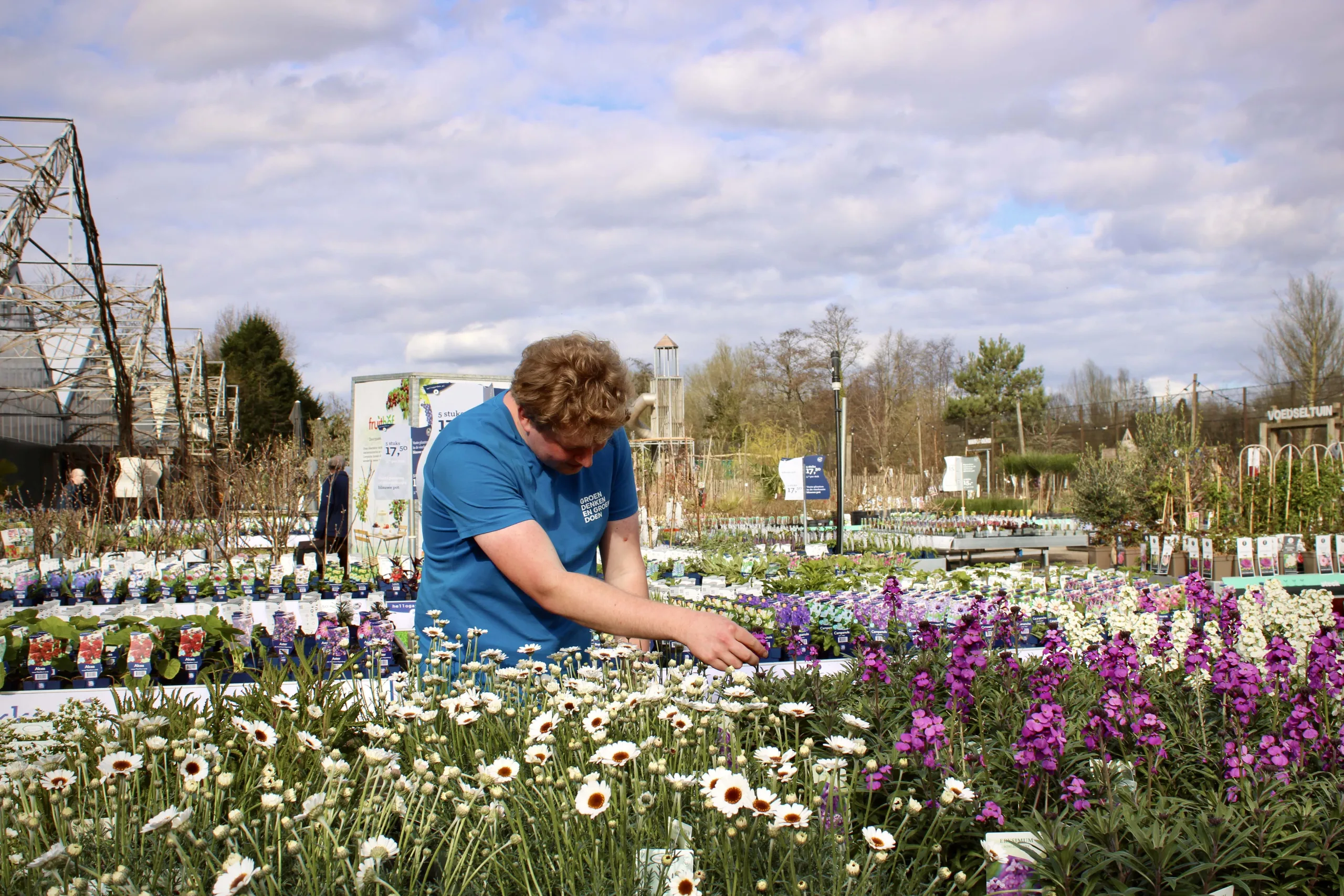 Medewerker Frans van Oostveen van tuincentrum Steck in Utrecht Overvecht staat tussen buiten tussen de tuinplanten te werken